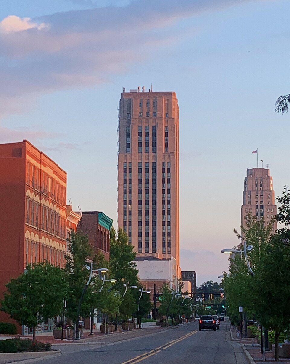 A downtown Battle Creek street at sunset, with the Art Deco tower rising above brick storefronts