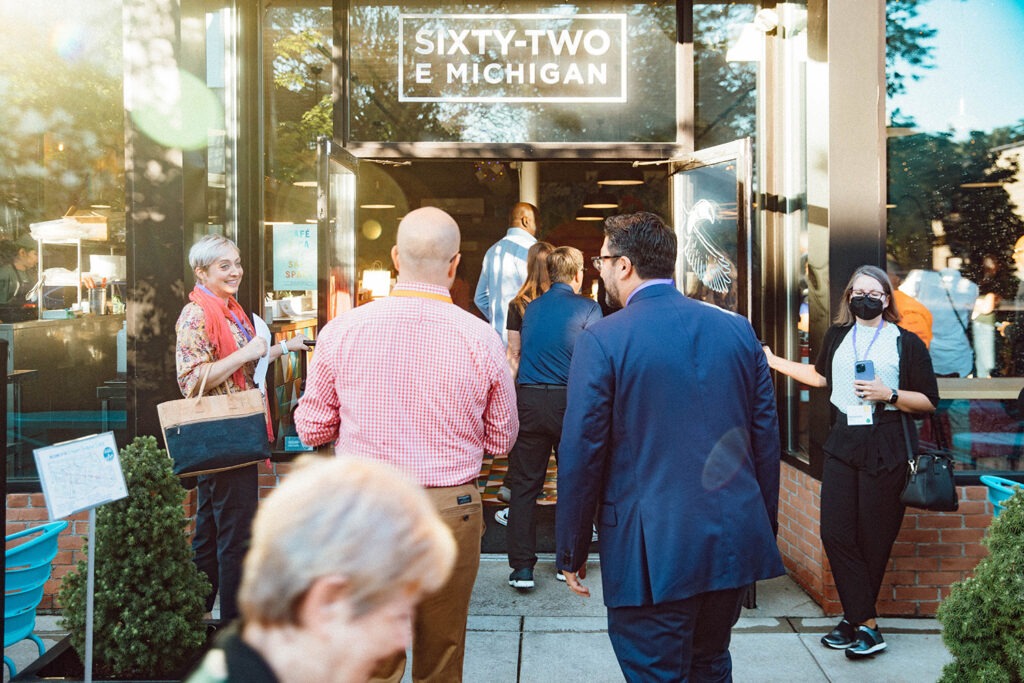 Guests walking through the front door of the Sixty-Two E Michigan storefront