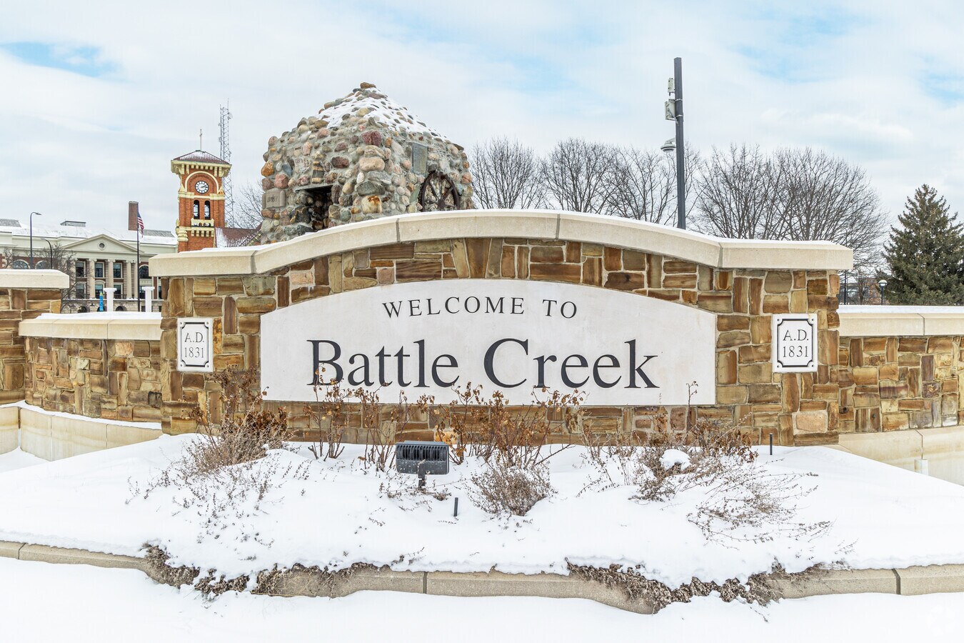 Stone welcome sign reading Welcome to Battle Creek, A.D. 1831, dusted with snow